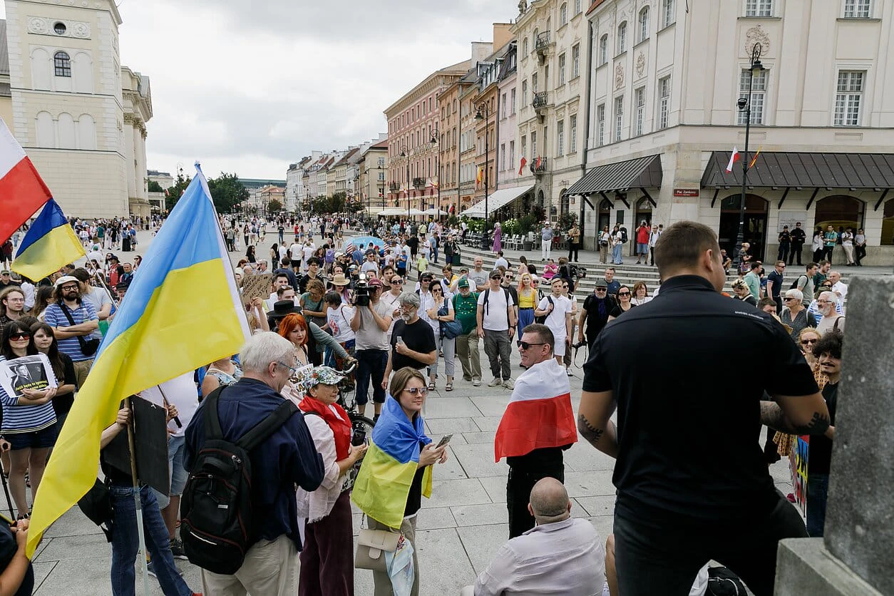 Учасники «Пікету добросусідства» на Замковій площі у Варшаві біля Колони Сигізмунда з прапорами Польщі, України та вільної